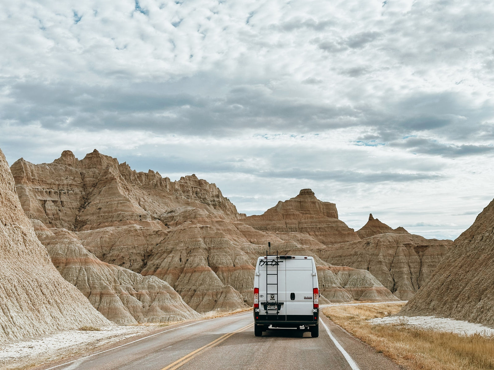 & cozy rear bed.|RV rental camper van drives through Badlands National Park