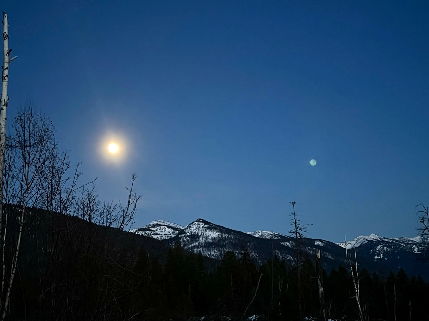 Explore tranquil moonlit mountains & dark skies by RV rental. Witness nature's beauty under two celestial bodies.