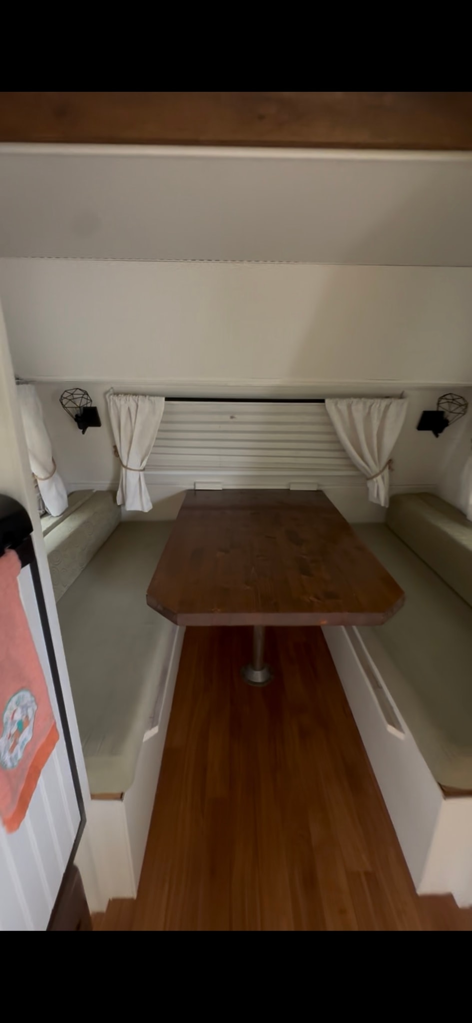 and coolers. Trees and blue sky above.|White travel trailer RV rental hitched to a pickup truck on a paved driveway