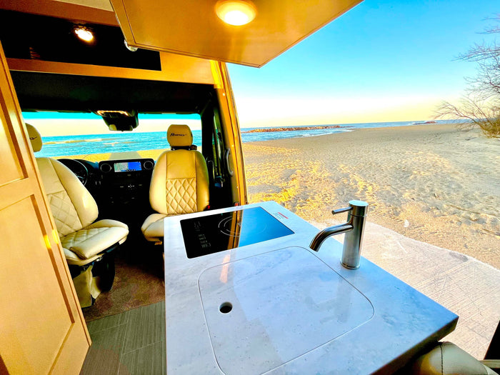 opens to a beach view.|Step inside this luxurious RV rental: a plush bed with wine