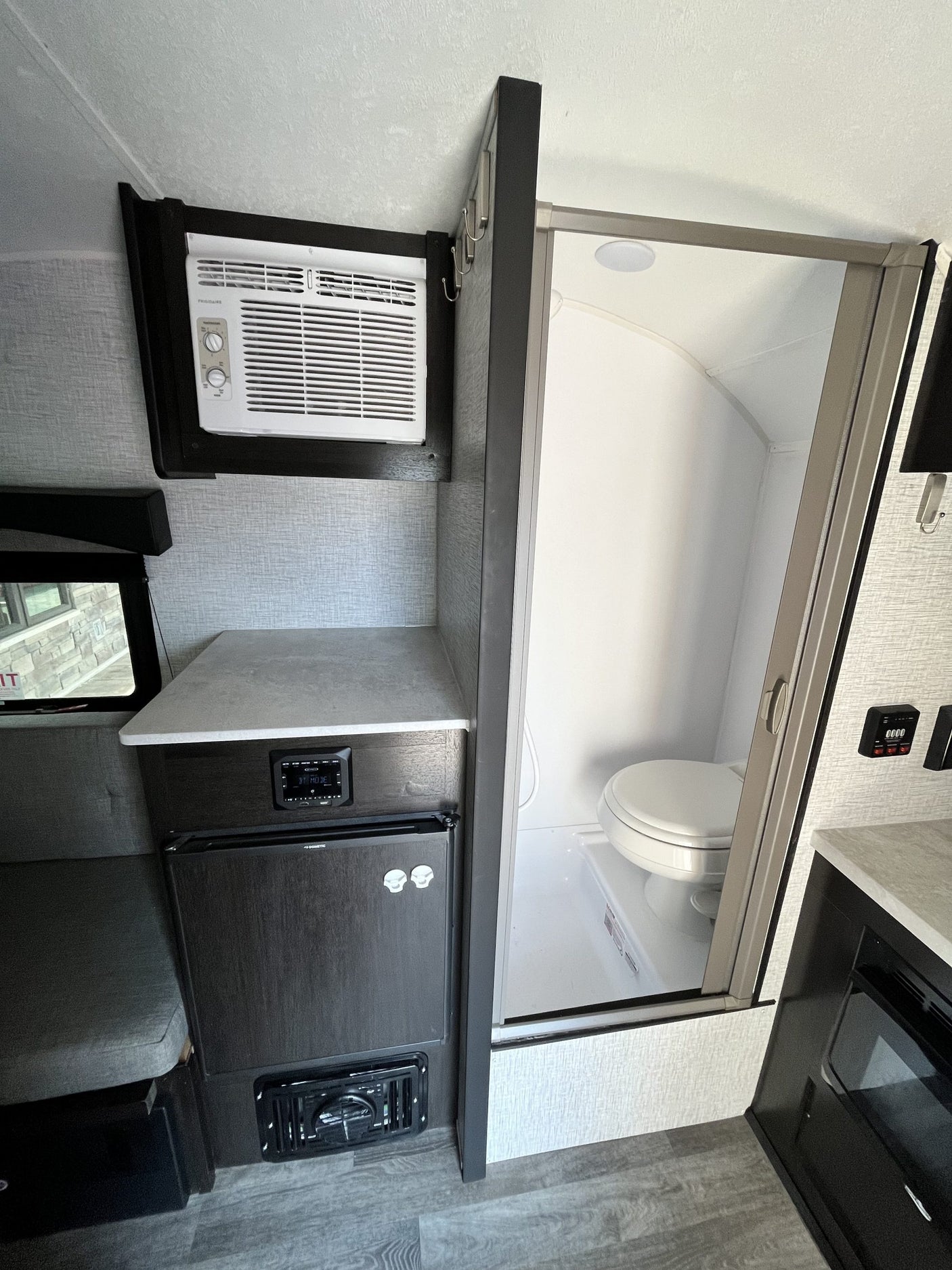Inside an **rv rental**: a built-in AC, compact kitchen with Dometic fridge, and a wet bath with toilet & shower.