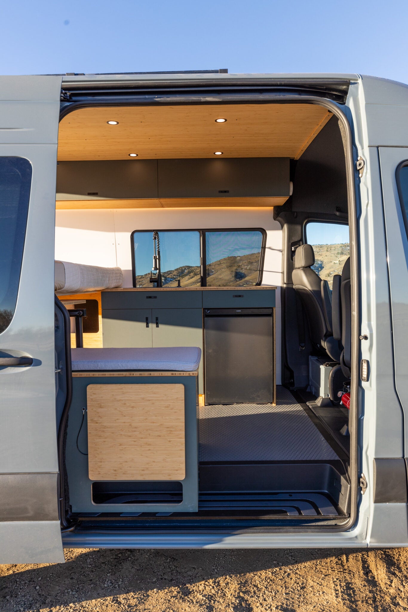 is parked on a scenic mountain road. Perfect for travel adventures!|Stunning RV rental interior with kitchen