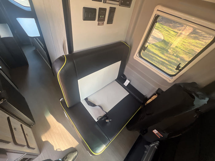 ready for your next adventure. Large windows show outside views.|Inside an RV rental: a comfortable black & white bench seat with a seatbelt