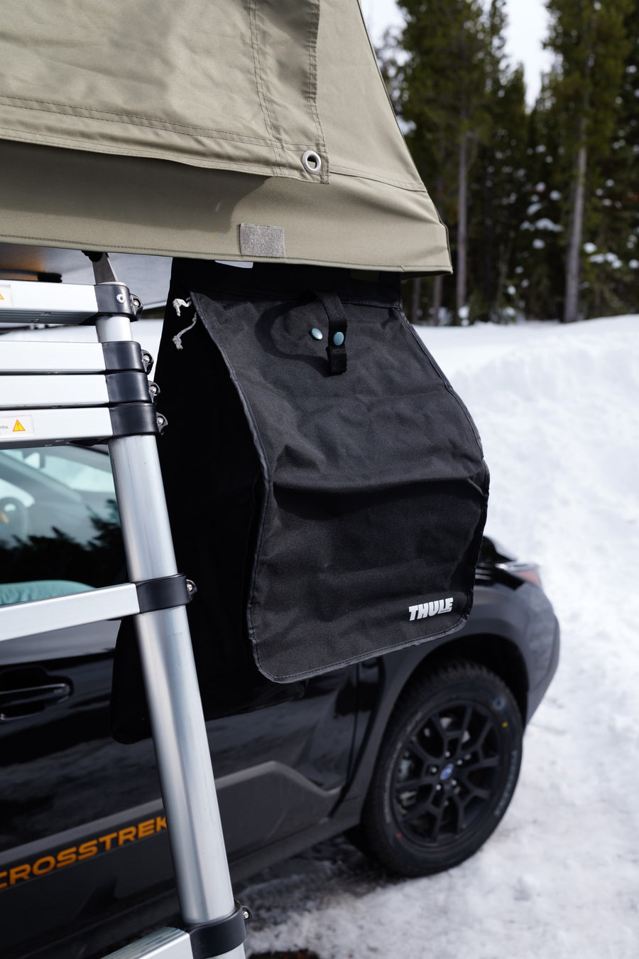 A Subaru Crosstrek with a Thule rooftop tent, ladder, and gear bag, ideal for RV rental wilderness trips.