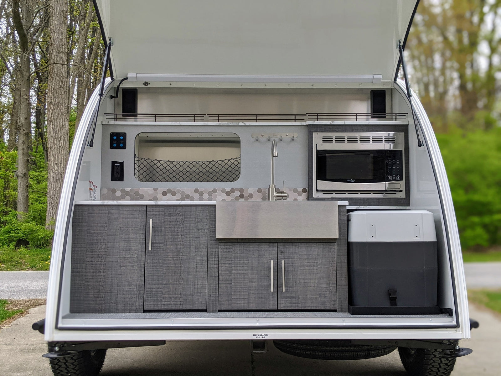 Explore with ease! This RV rental features a fully equipped outdoor kitchen in a compact camper, ready for your mobile adventures.
