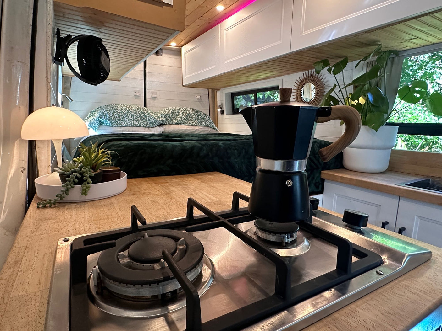 hinting at adventure.|Cozy camper van interior featuring a comfortable bed