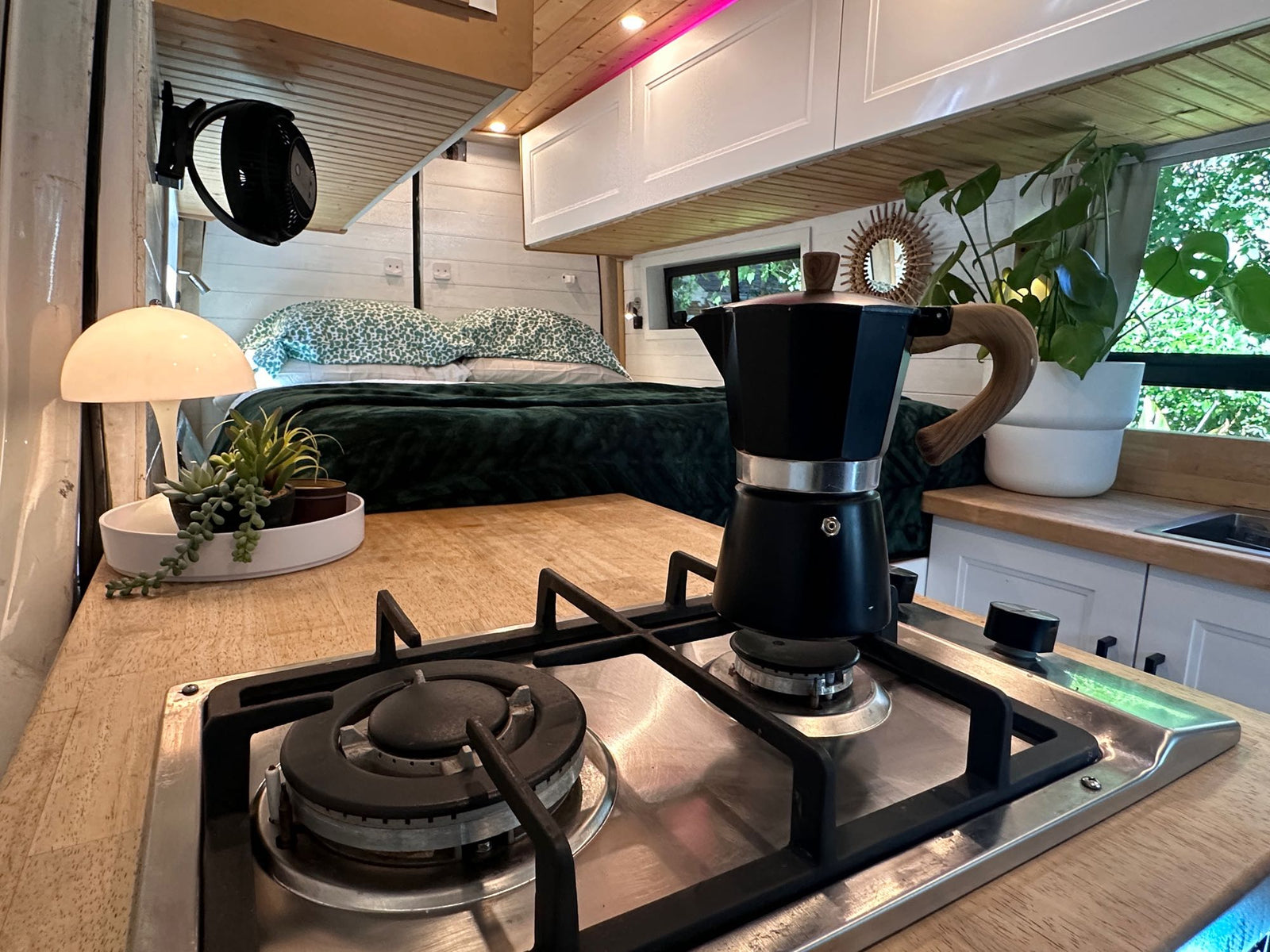 hinting at adventure.|Cozy camper van interior featuring a comfortable bed