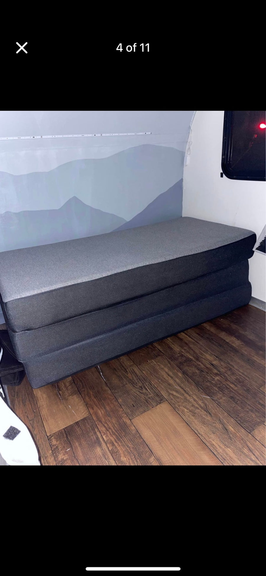 three-section foldable mattress on a dark wood floor