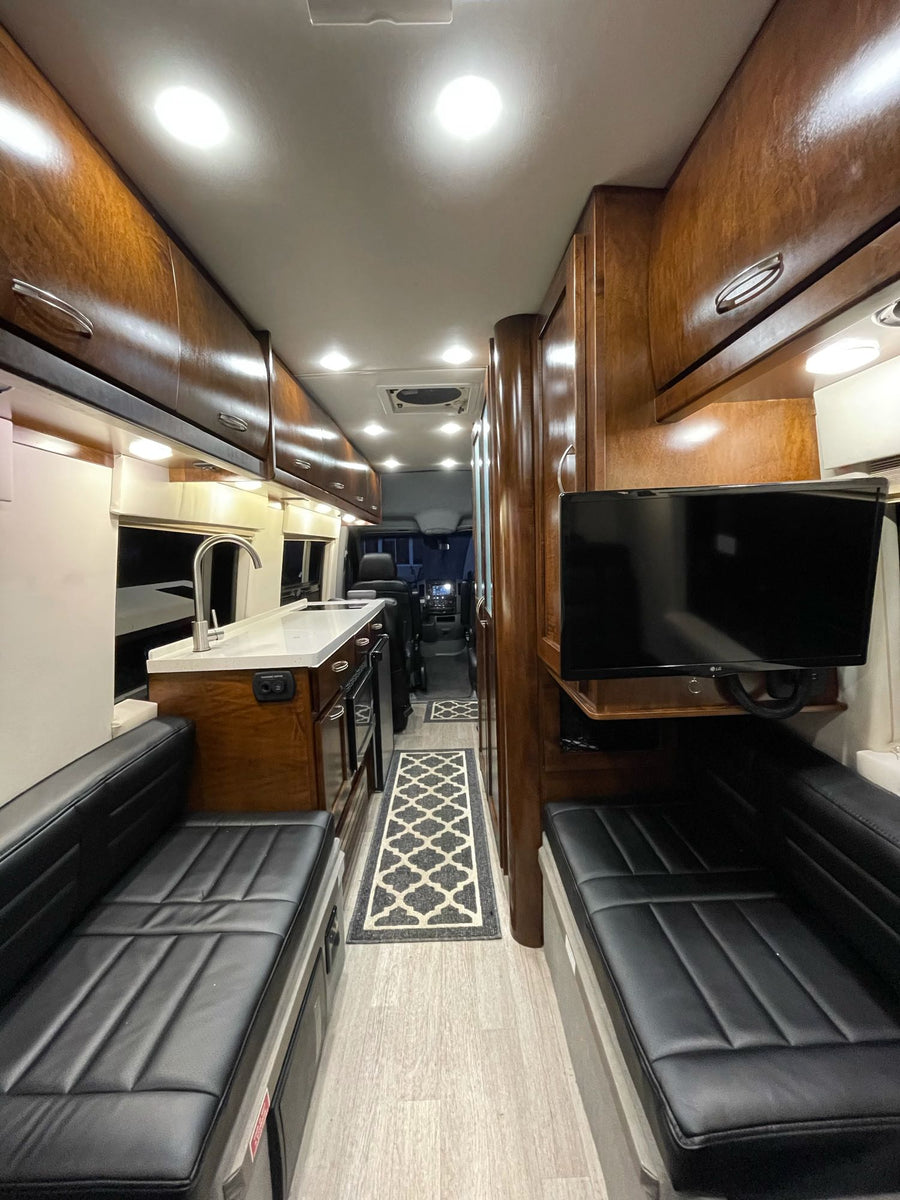 parked outside a modern house.|Inside a Galleria luxury rv rental: sleek black leather seats