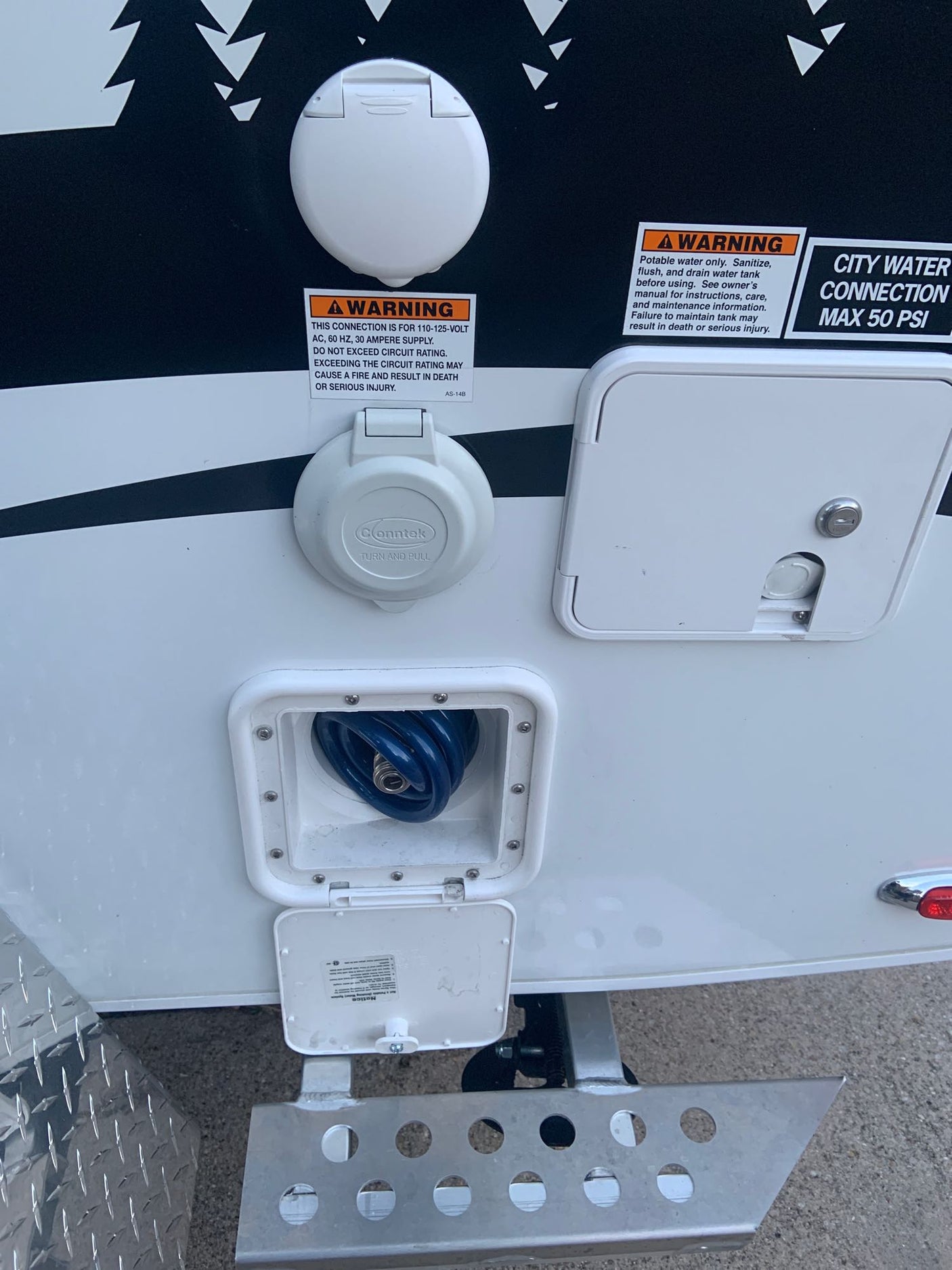 An RV rental's exterior utility panel with power, city water, and outdoor shower connections. Ready for your adventure.