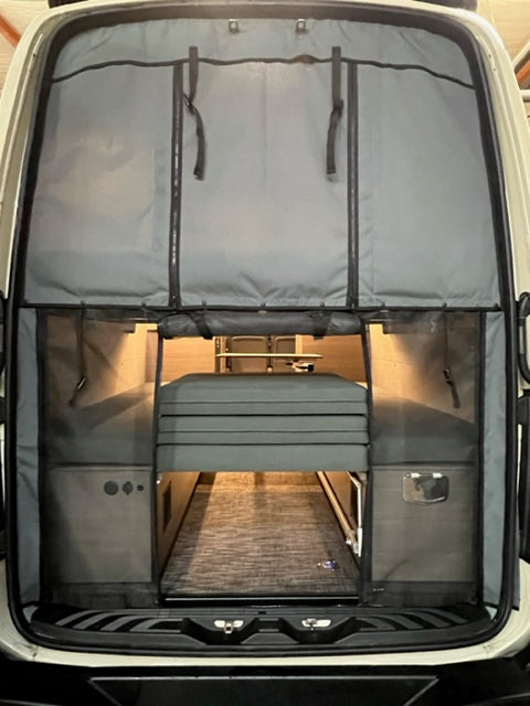 RV rental: Inside a camper van, showing smart storage panels, a neatly folded bed, and functional interior space.