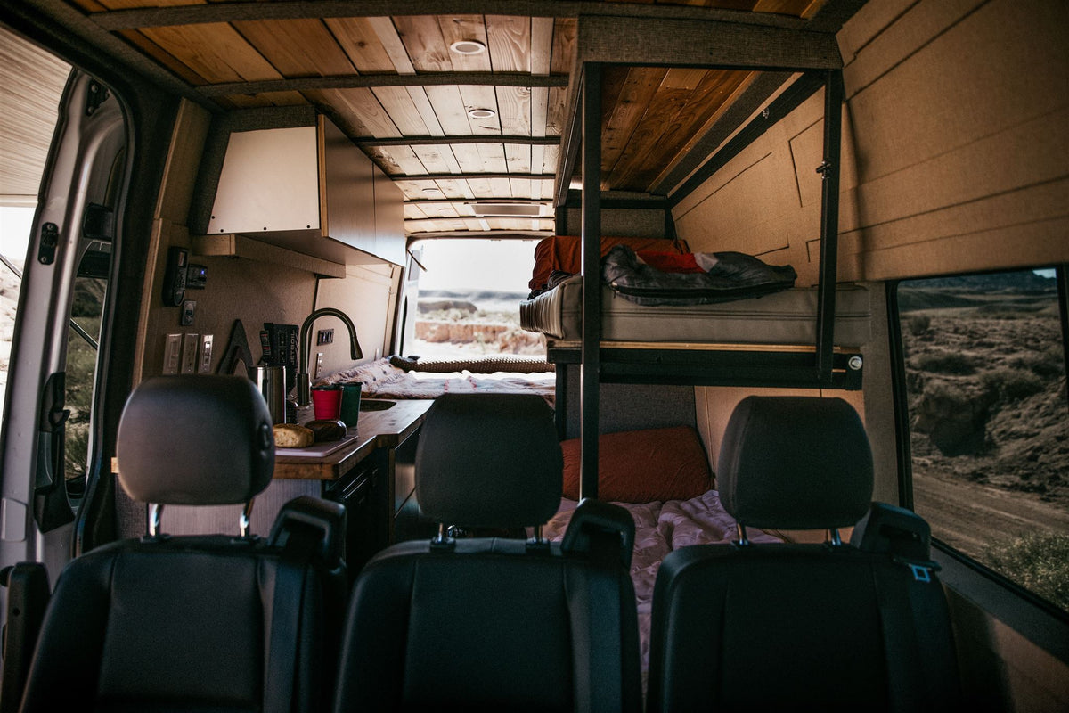 and comfy sleeping areas.|Comfortable RV rental interior: A person sleeps soundly on a lower bunk — photo 9