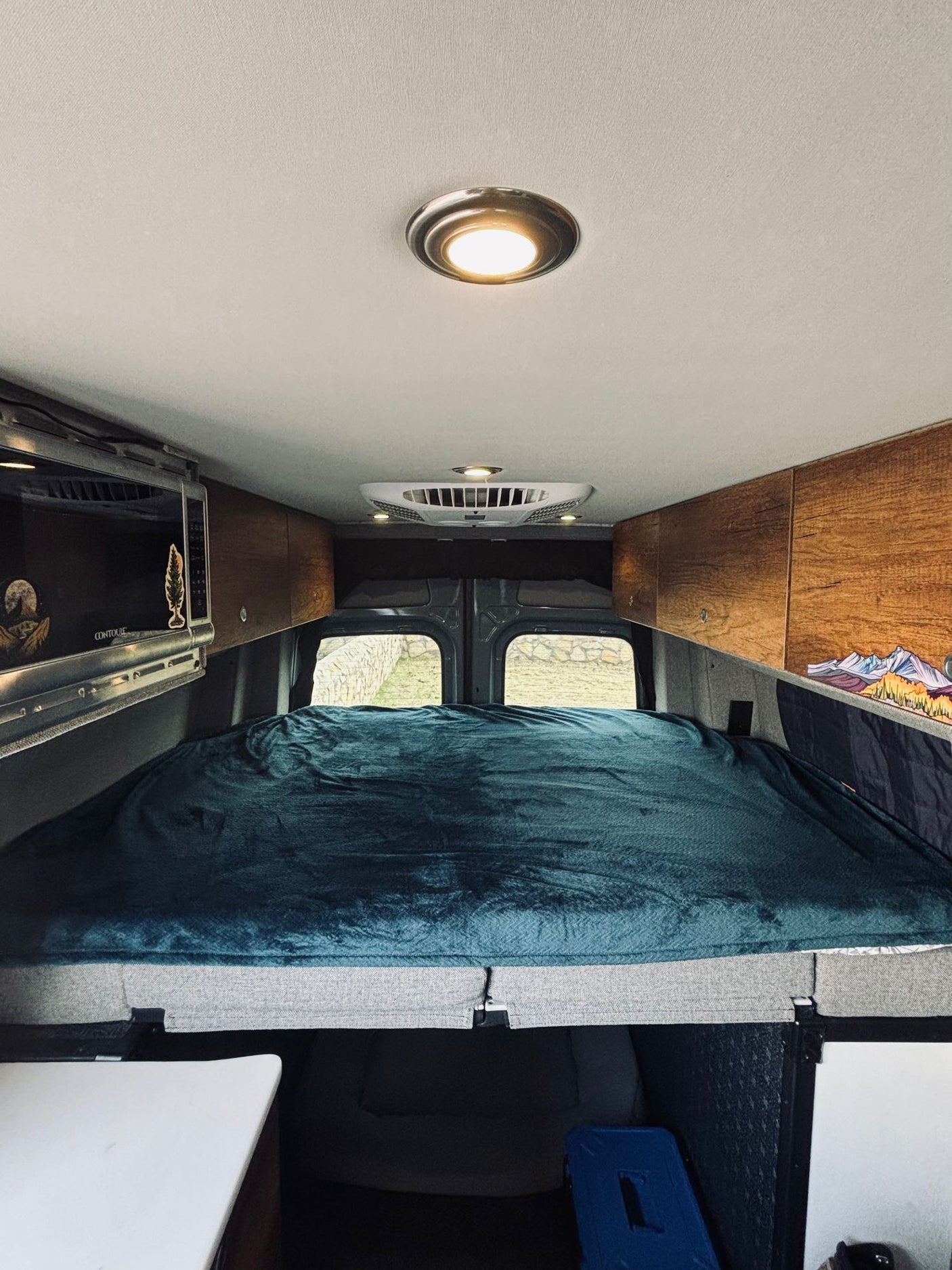 Step inside this RV rental! Features a comfy bed, overhead storage, and microwave, ready for your road trip comfort.