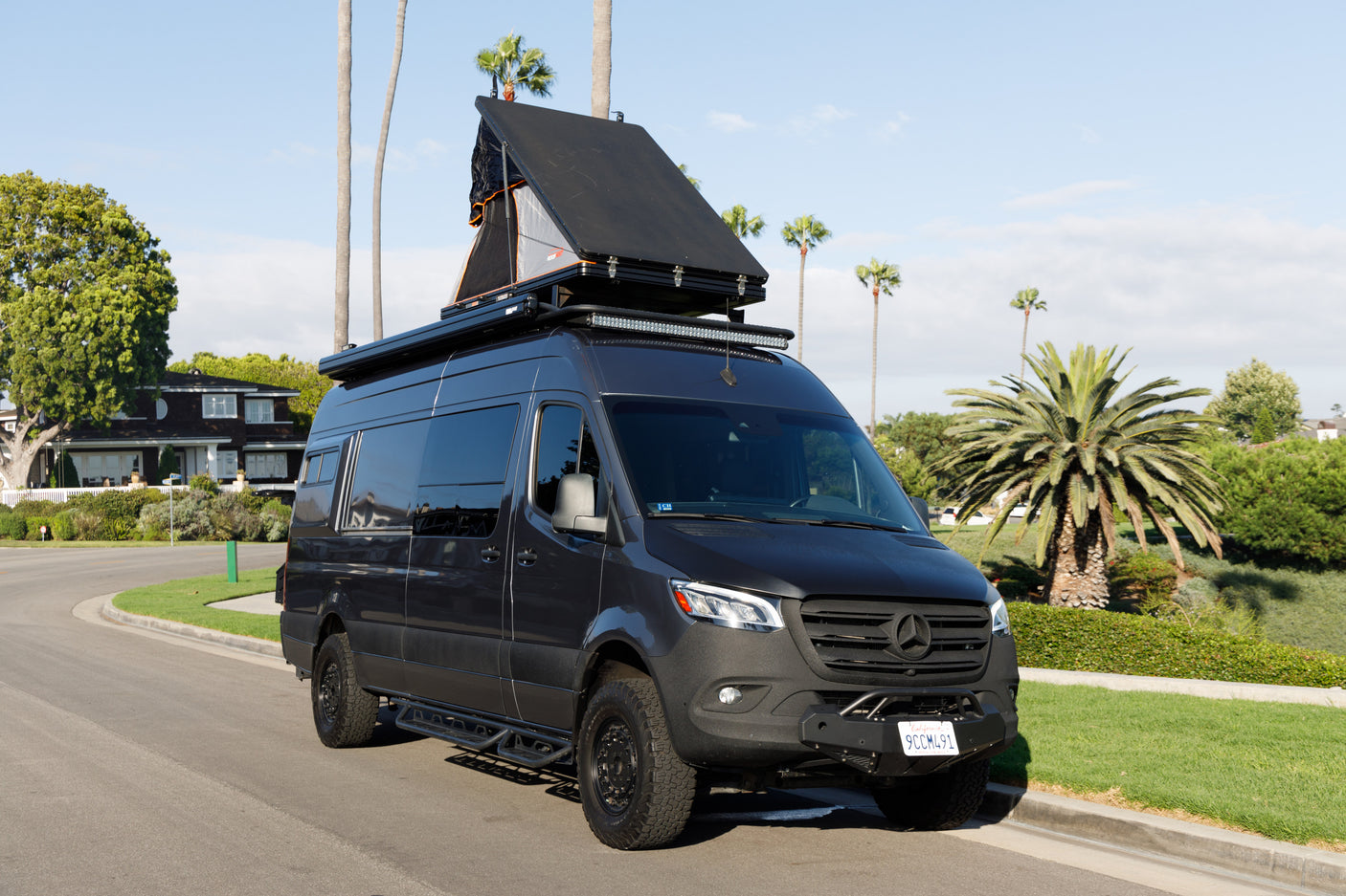 This Mercedes-Benz Sprinter adventure rv rental, with its open rooftop tent, is ready for off-grid camping.