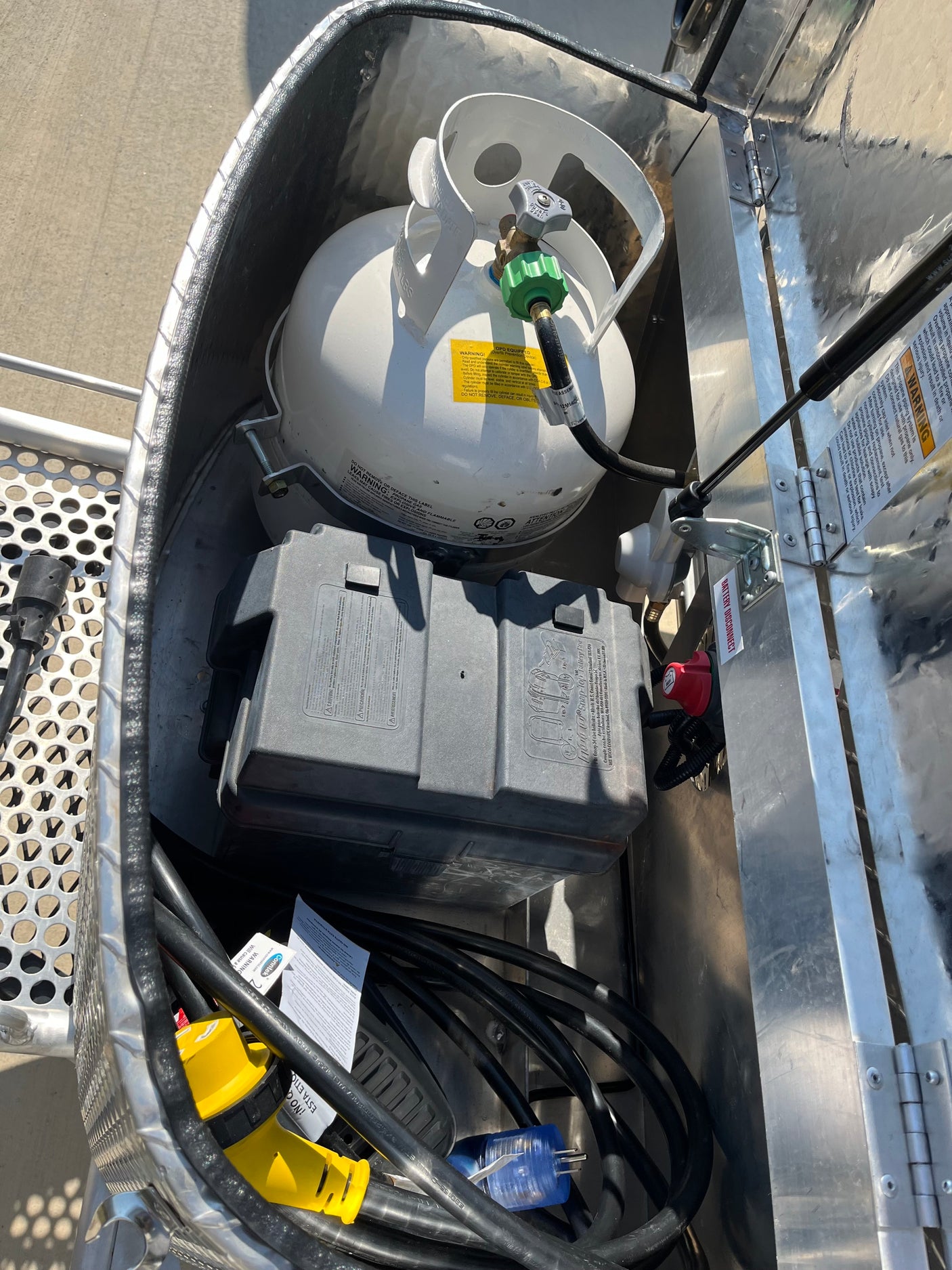 RV rental utility compartment: propane tank, battery, and electrical power cords for your trip.