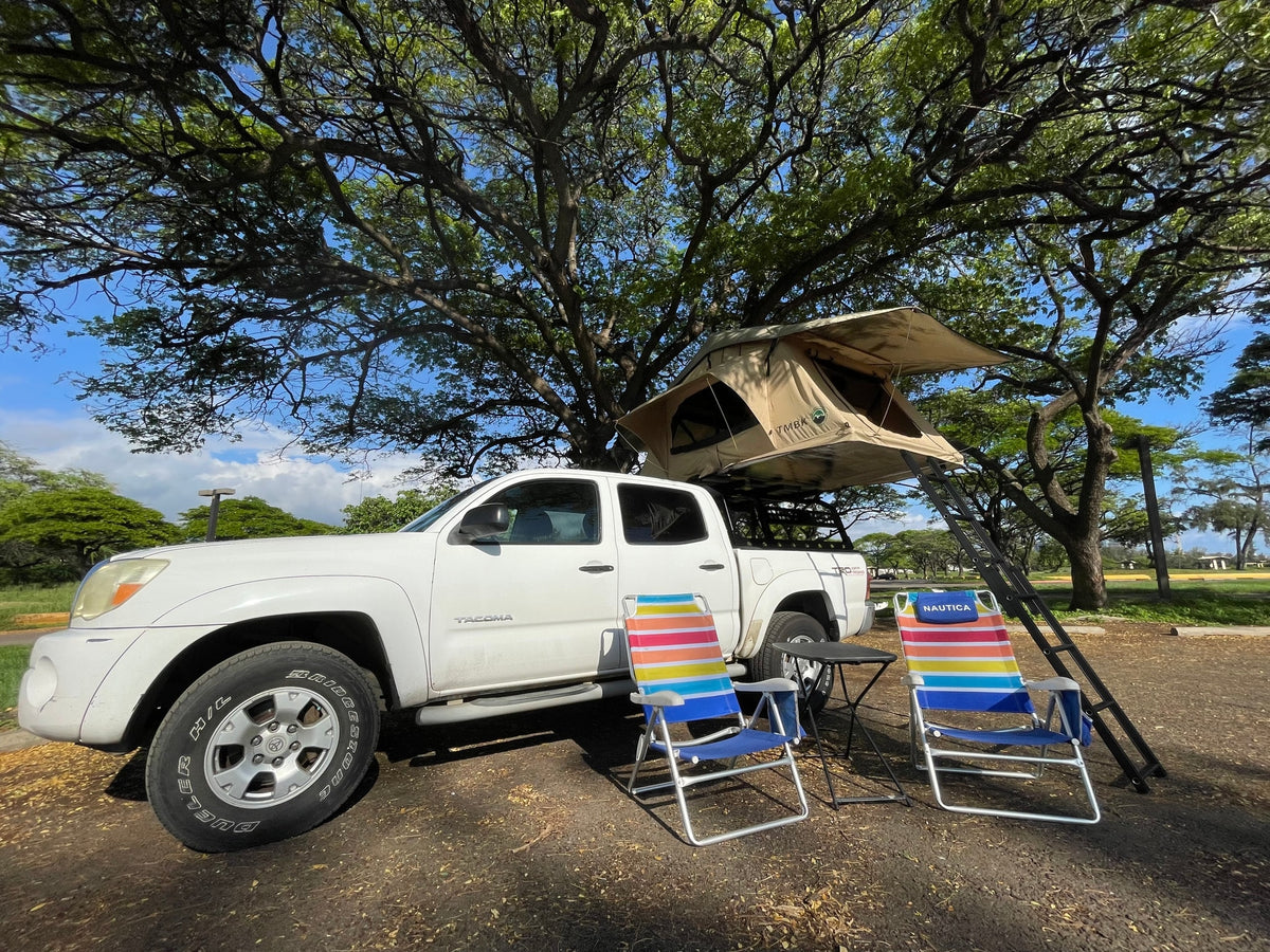 White truck with a rooftop tent & camp setup under a large tree. A perfect outdoor RV rental for shaded adventure. — photo 10