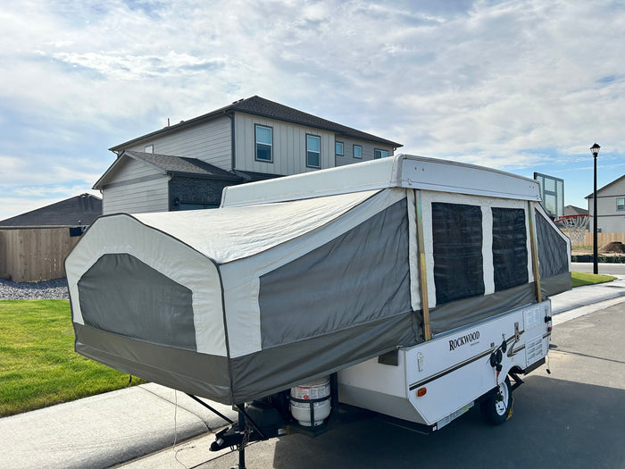 This Rockwood Freedom pop-up camper, perfect for an rv rental, is extended and set up in a residential area.