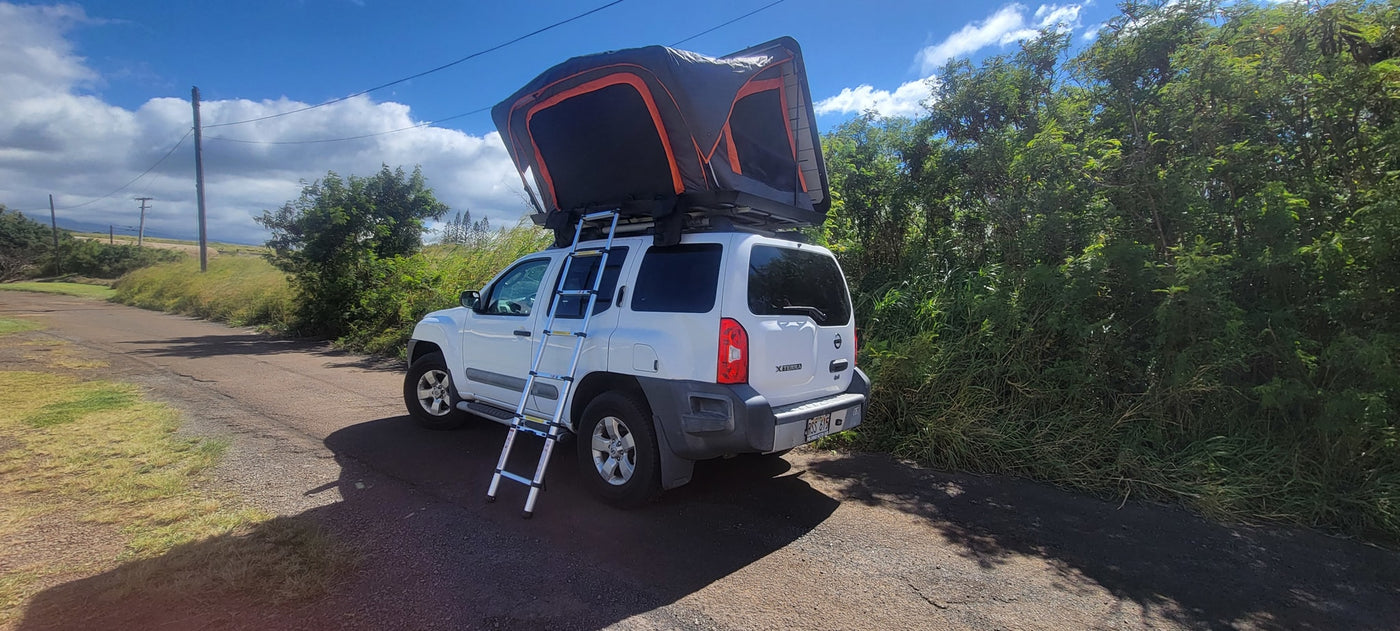 This white SUV with a deployed roof-top tent and ladder is ready for an outdoor 'RV rental' adventure on a dirt road. — photo 5