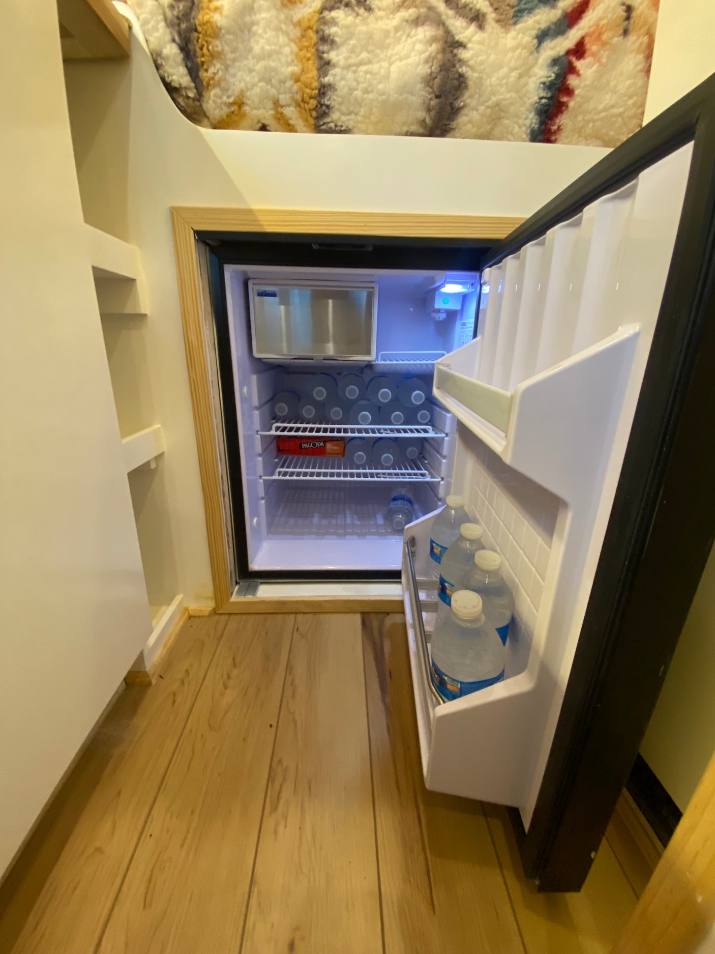 This RV rental features a bright mini-fridge, packed with water bottles and an ice maker, ideal for travel.