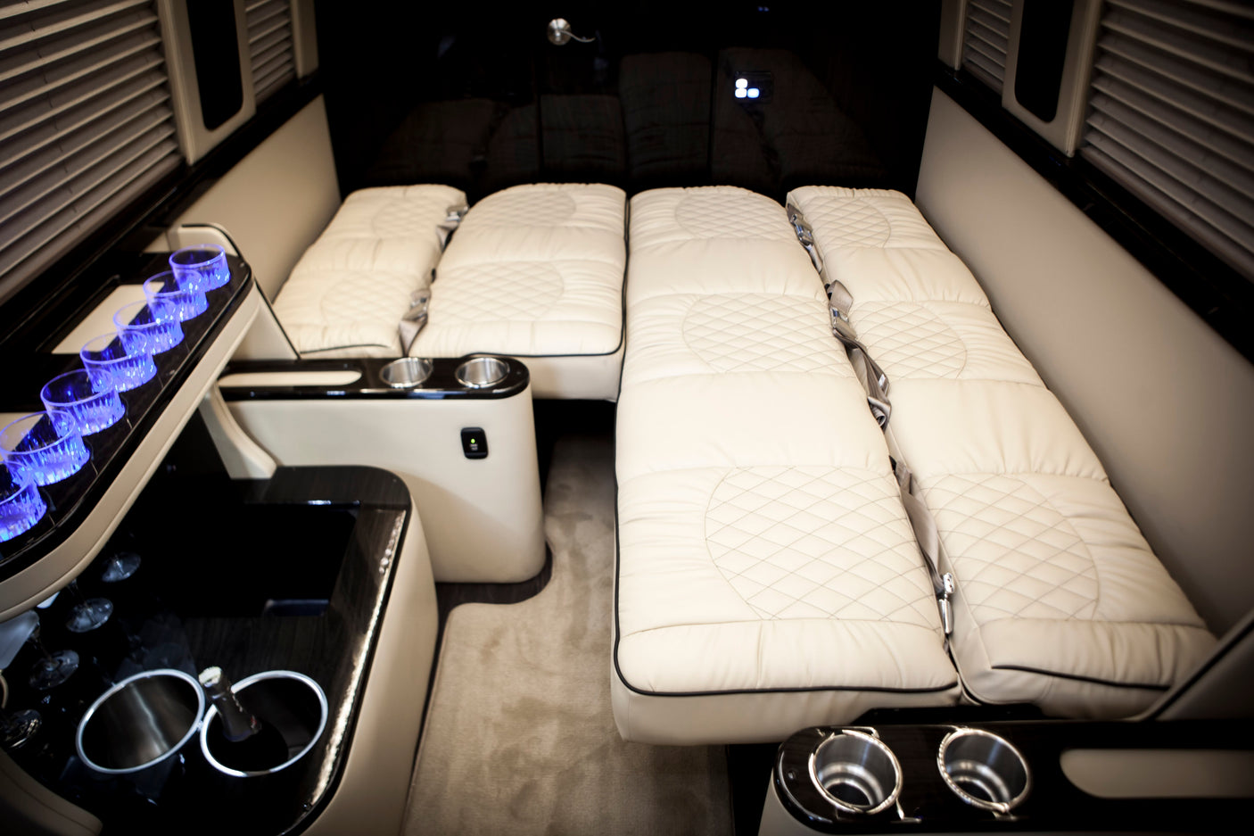 Luxury RV rental interior: plush cream seating/beds, ambient blue lighting, & sleek amenities for comfortable travel.