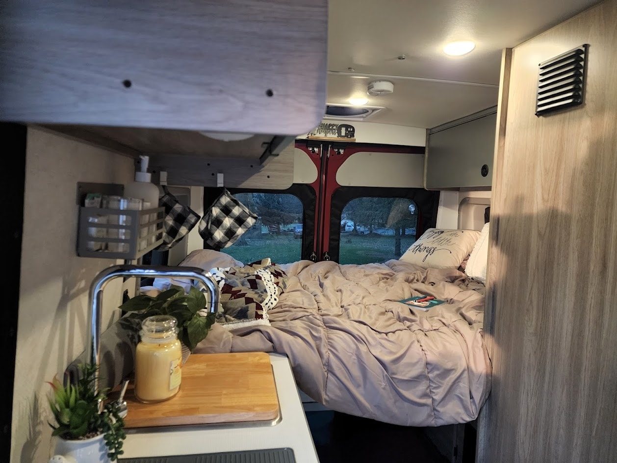 Experience van life! This rv rental offers a comfortable bed, compact kitchen, and storage for your road trip.