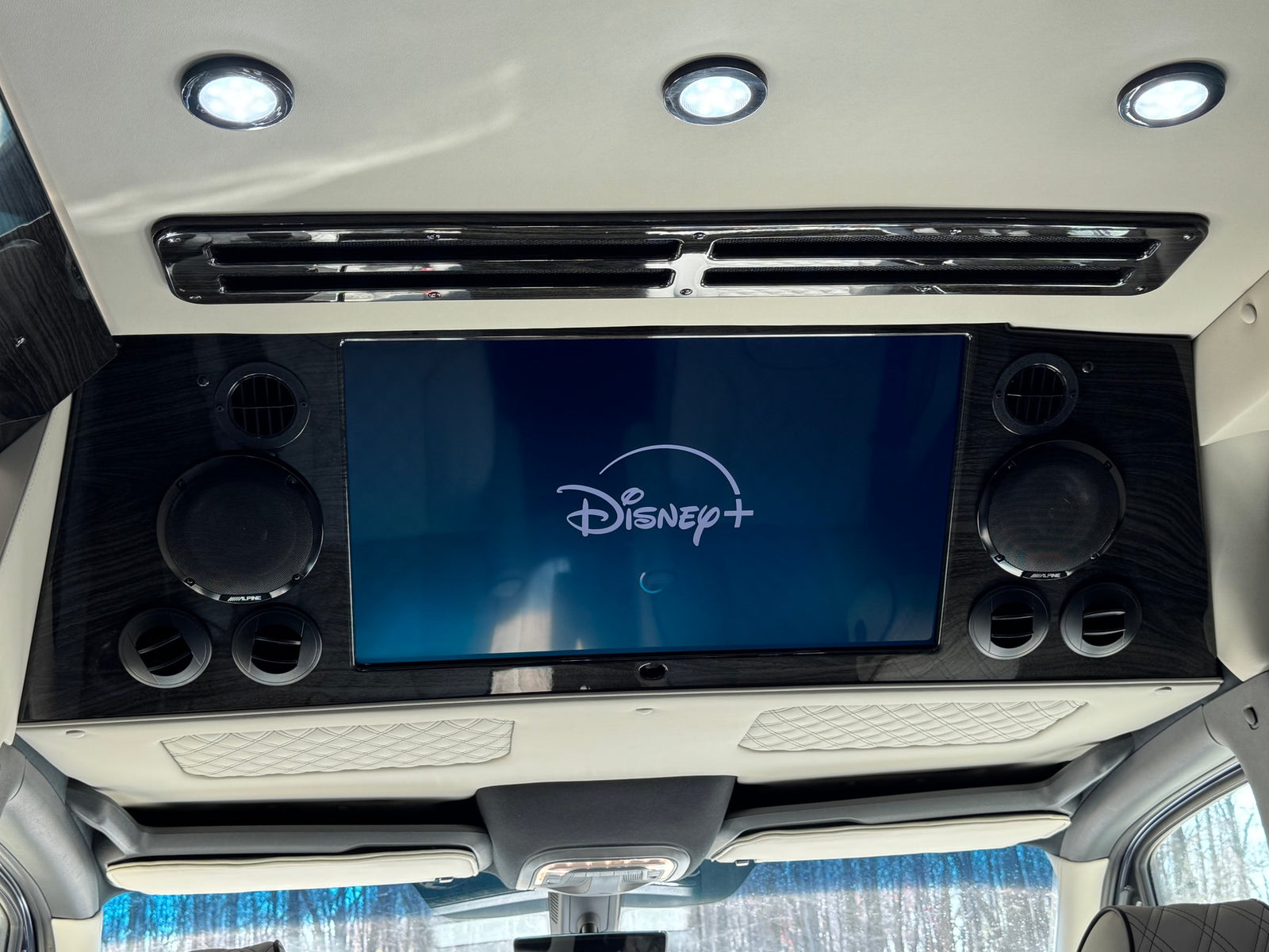 custom power & refrigerator buttons.|Luxurious custom RV rental interior features four quilted leather captain's chairs