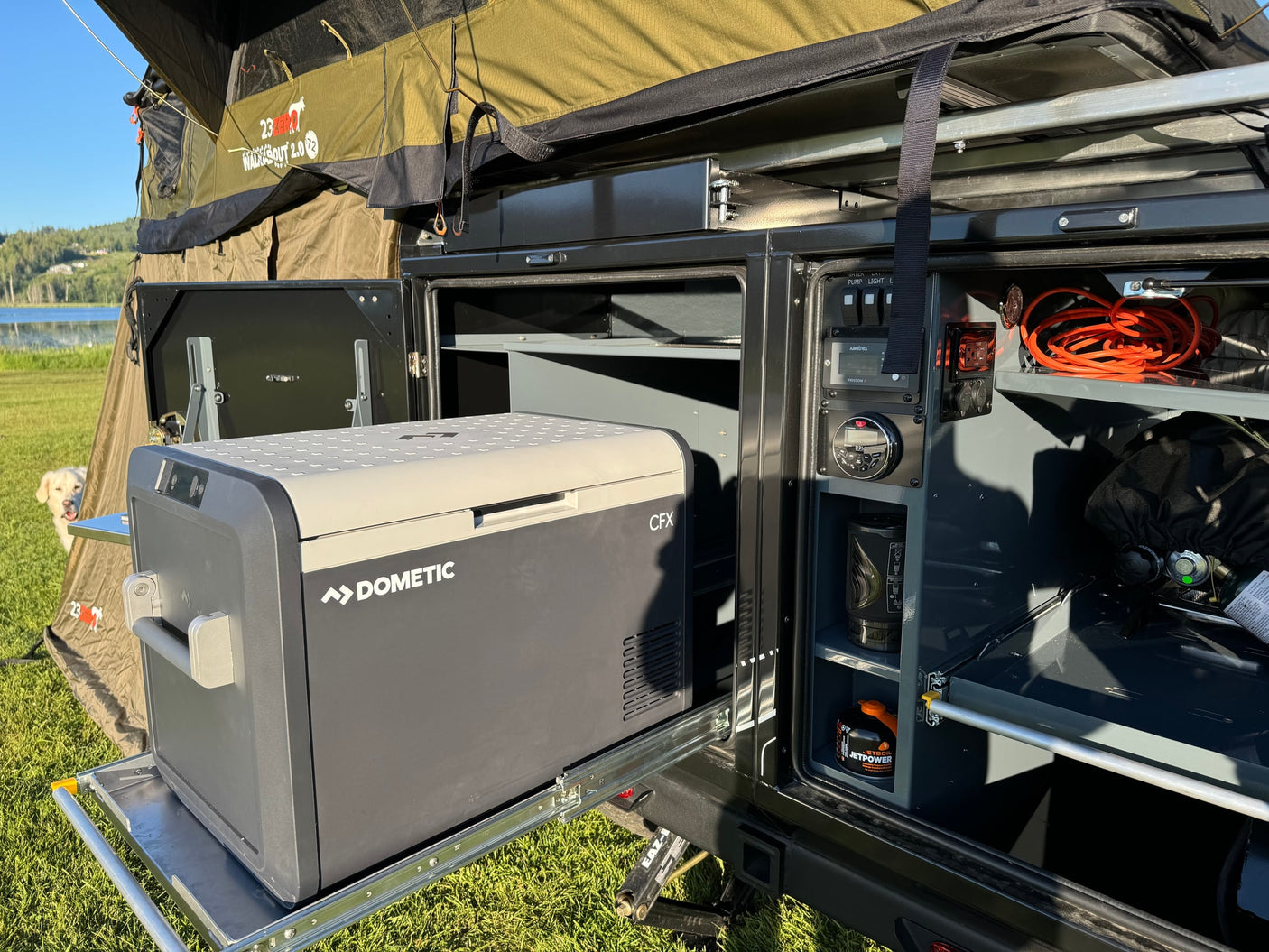 RV rental setup: Dometic fridge on slide-out, 23ZERO rooftop tent, & camp kitchen essentials for outdoor living.