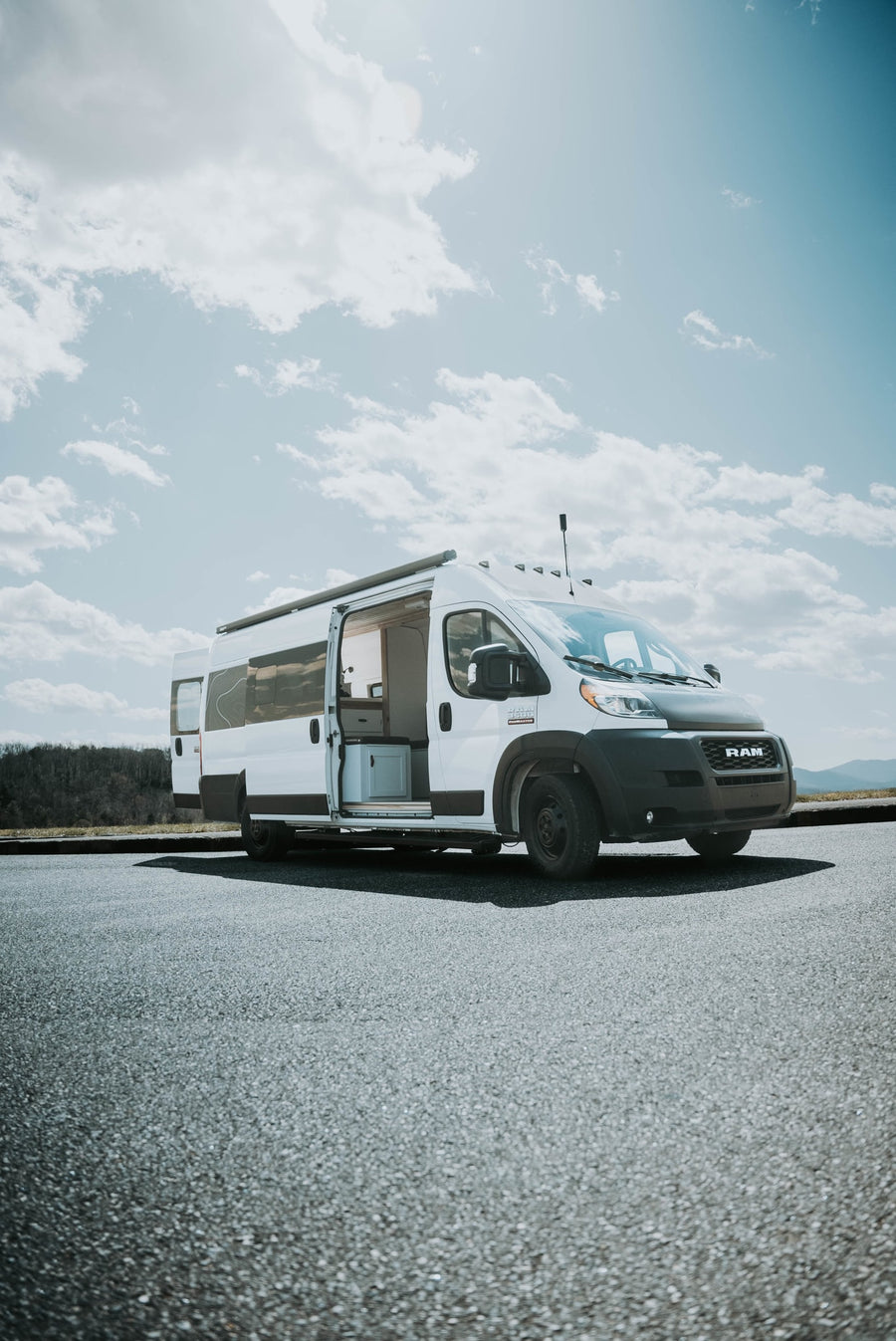 showcasing its interior.|White Ram ProMaster camper van RV rental parked on asphalt