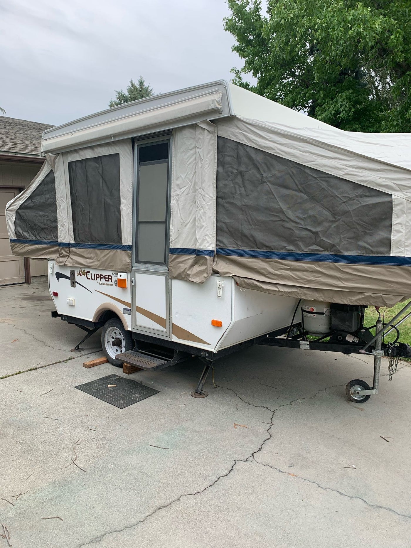 A white pop-up RV, a Clipper by Coachmen, fully set up on concrete. Perfect for an RV rental camping experience. — photo 1