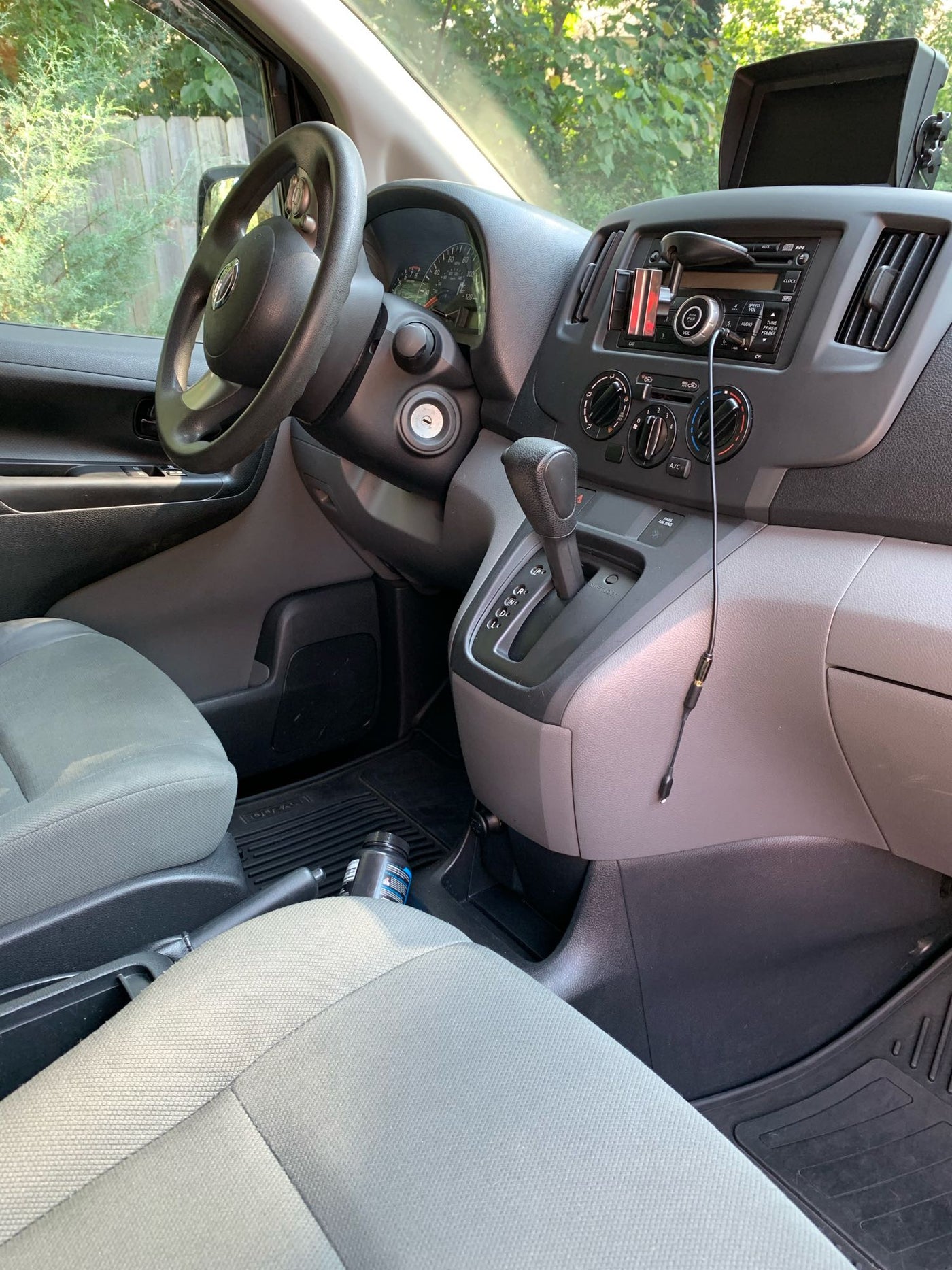 Inside a compact Nissan cargo van, potentially an RV rental base, showing the dashboard, steering wheel, and automatic shifter. — photo 6