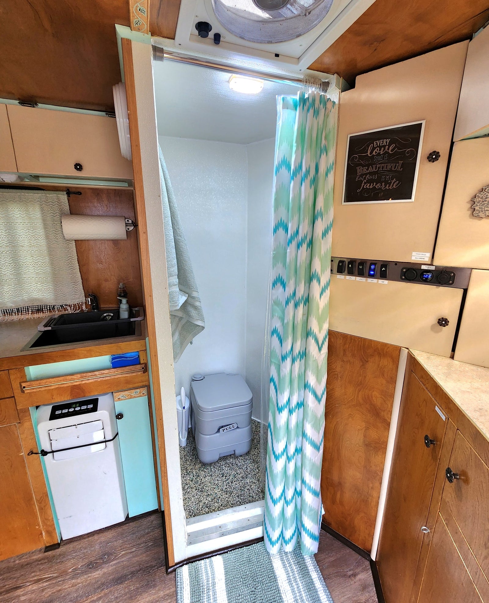 and charming decor.|This RV rental's cozy dining nook features a rustic table with place settings & serene window views.|Cozy rv rental interior: bed