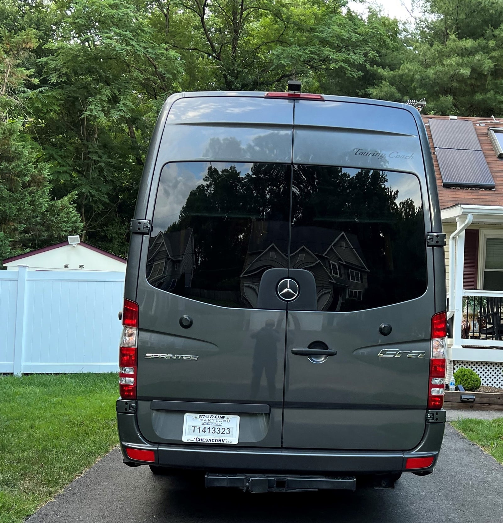 parked in a lot.|This compact grey Sprinter camper van