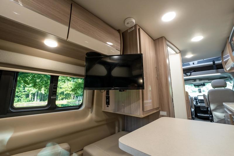 and natural light from large windows.|Spacious RV rental interior with a TV