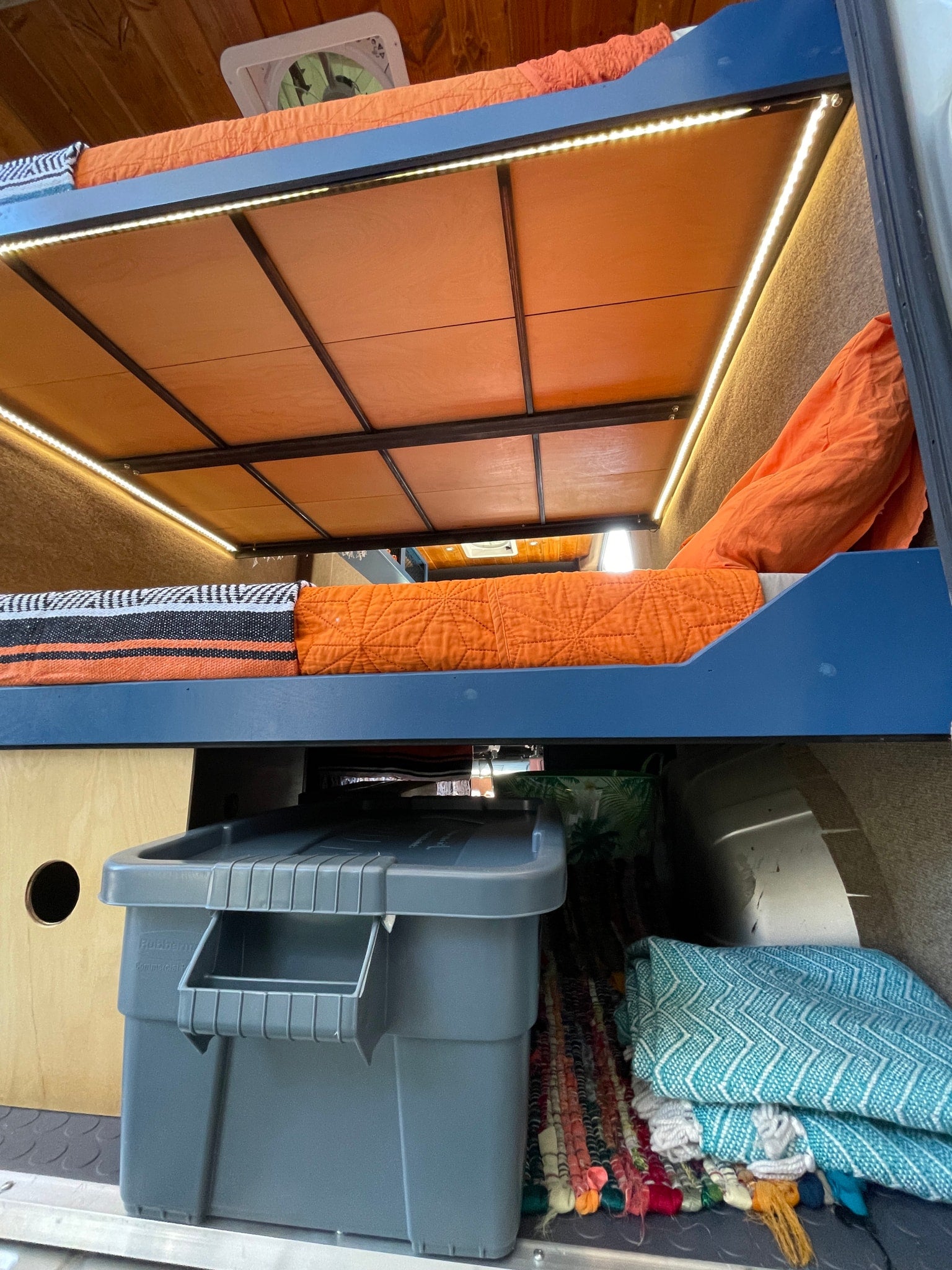 and a beautiful wood ceiling.|This RV rental shows a camper van's open rear doors revealing bunk beds