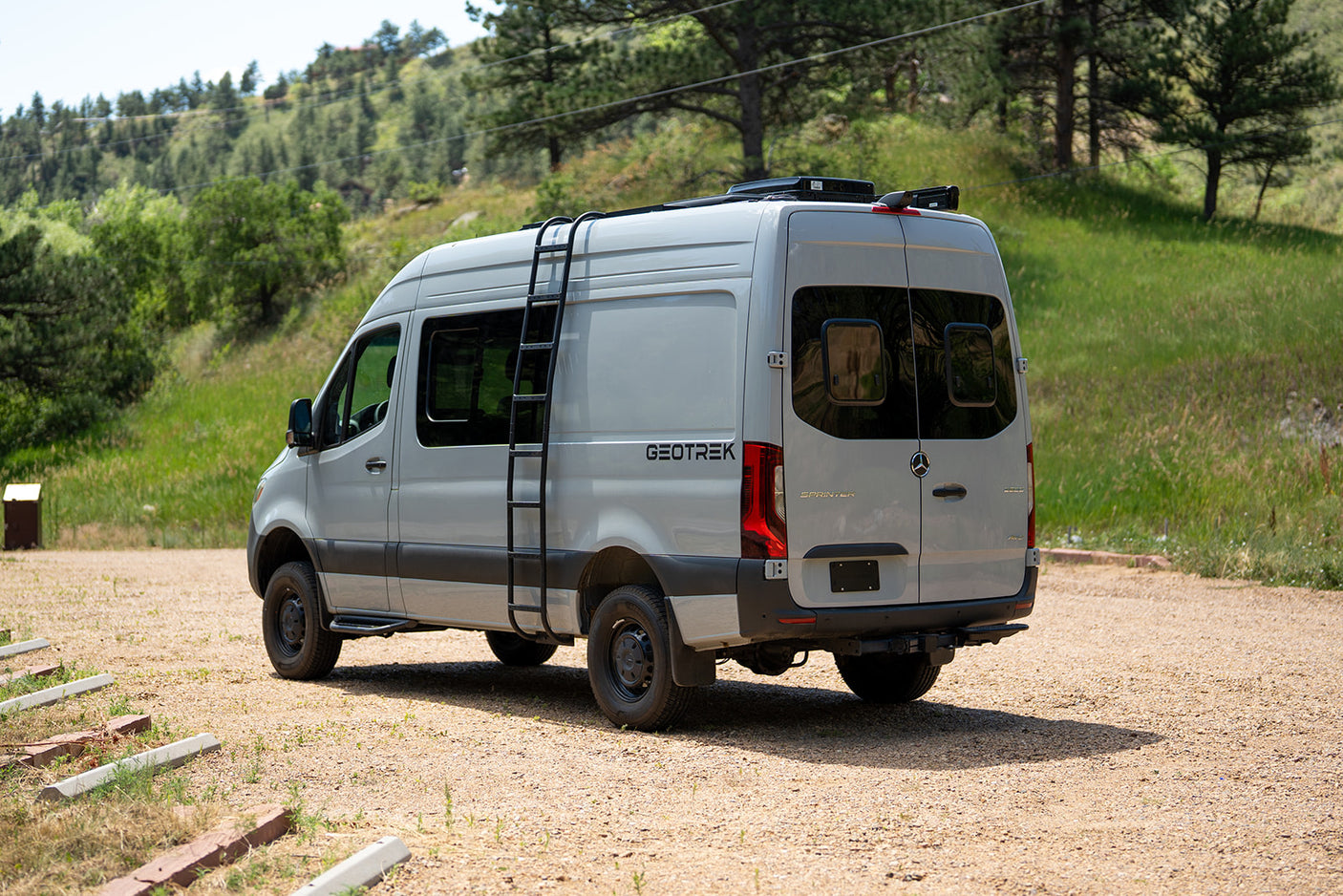 Explore nature with this custom Mercedes Sprinter rv rental. Grey camper van with roof ladder, ideal for off-grid adventures.