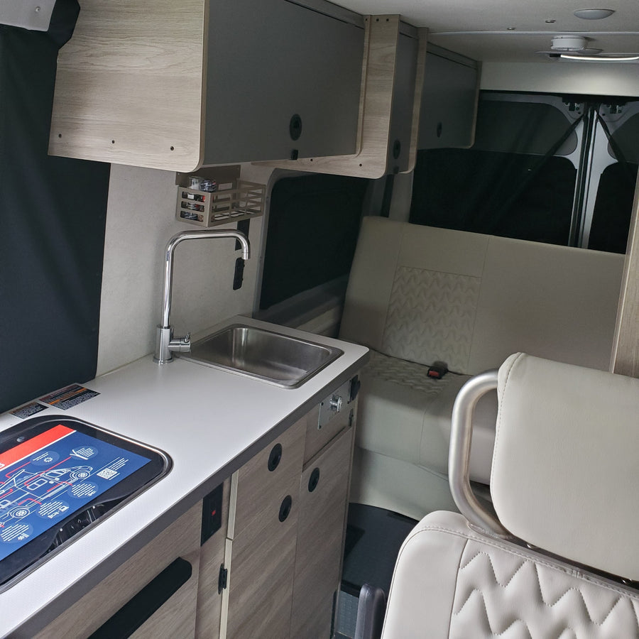 with a dog "driving" and a person visible inside.|Celebrating a new rv rental! A smiling couple poses with their silver Winnebago Solis camper van.|Winnebago Solis RV rental: A happy dog inside a cozy camper van