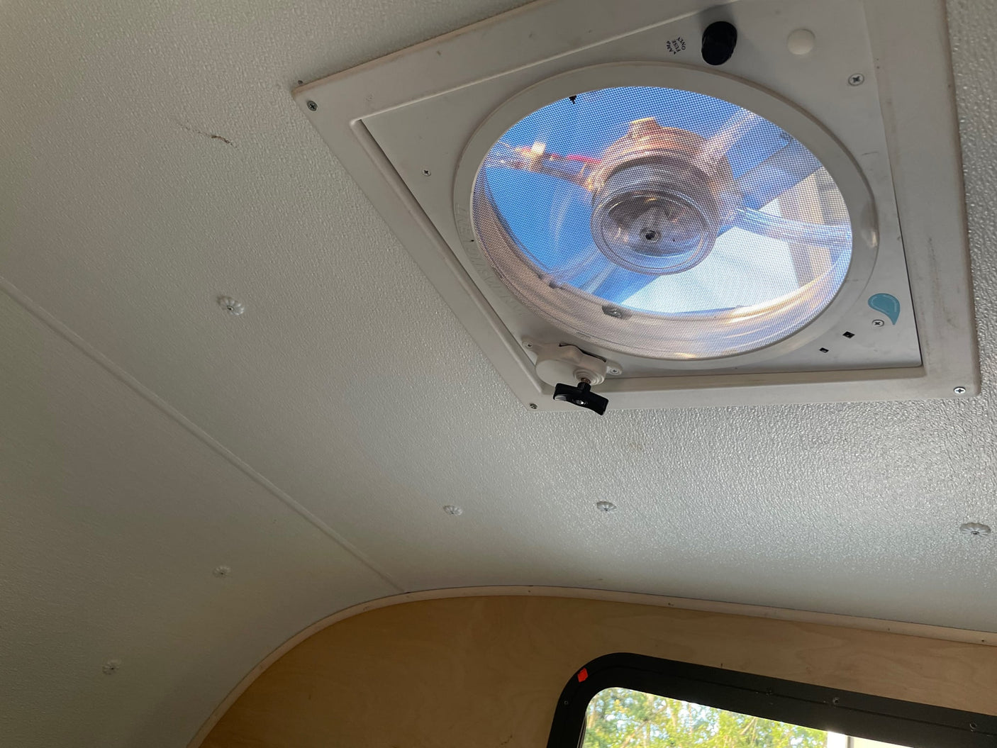 and wiring in open compartments.|RV rental food truck interior: Upper lighted cabinets with checkered shelves