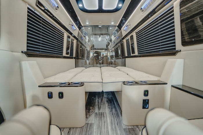 side door open to reveal cream leather seats & lighted interior.|Inside a premium rv rental: cream leather captain's chairs
