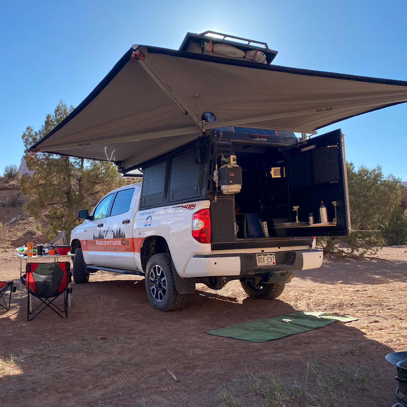 Overland adventure awaits! White truck camper with awning & full setup