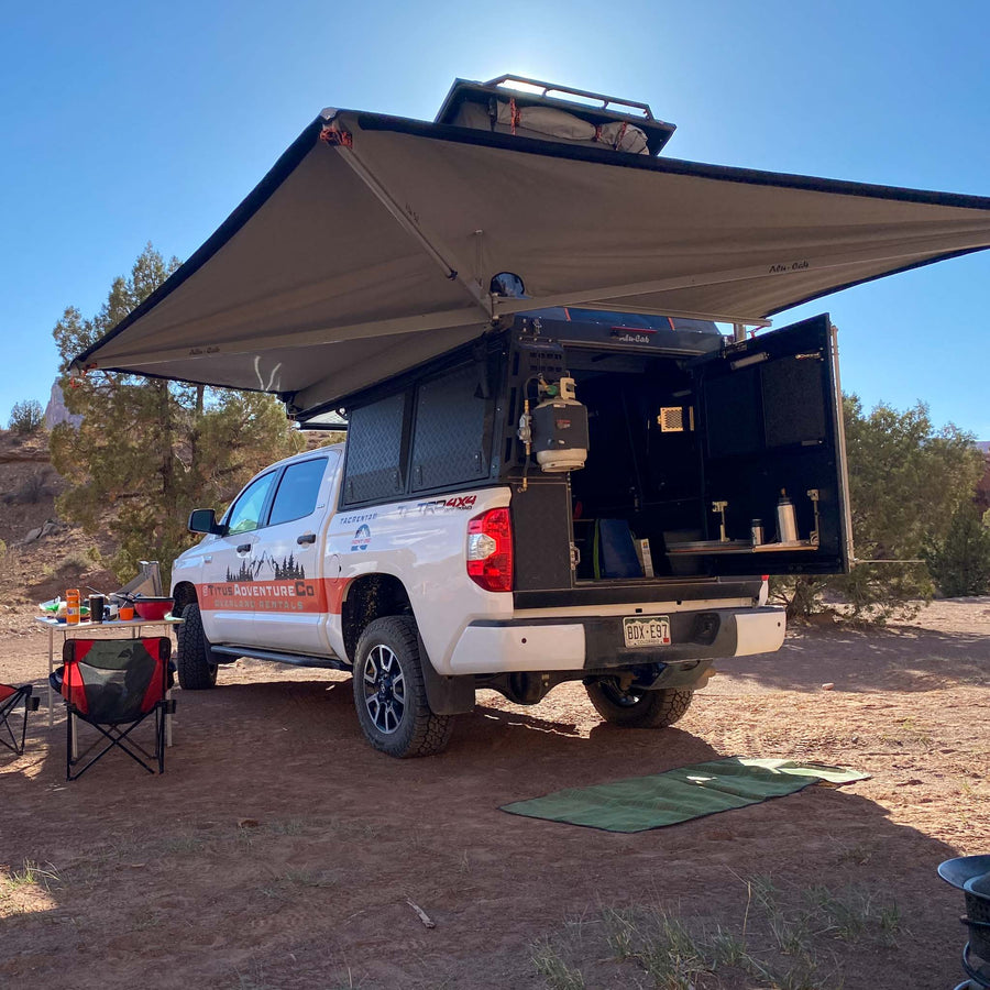 Overland adventure awaits! White truck camper with awning & full setup