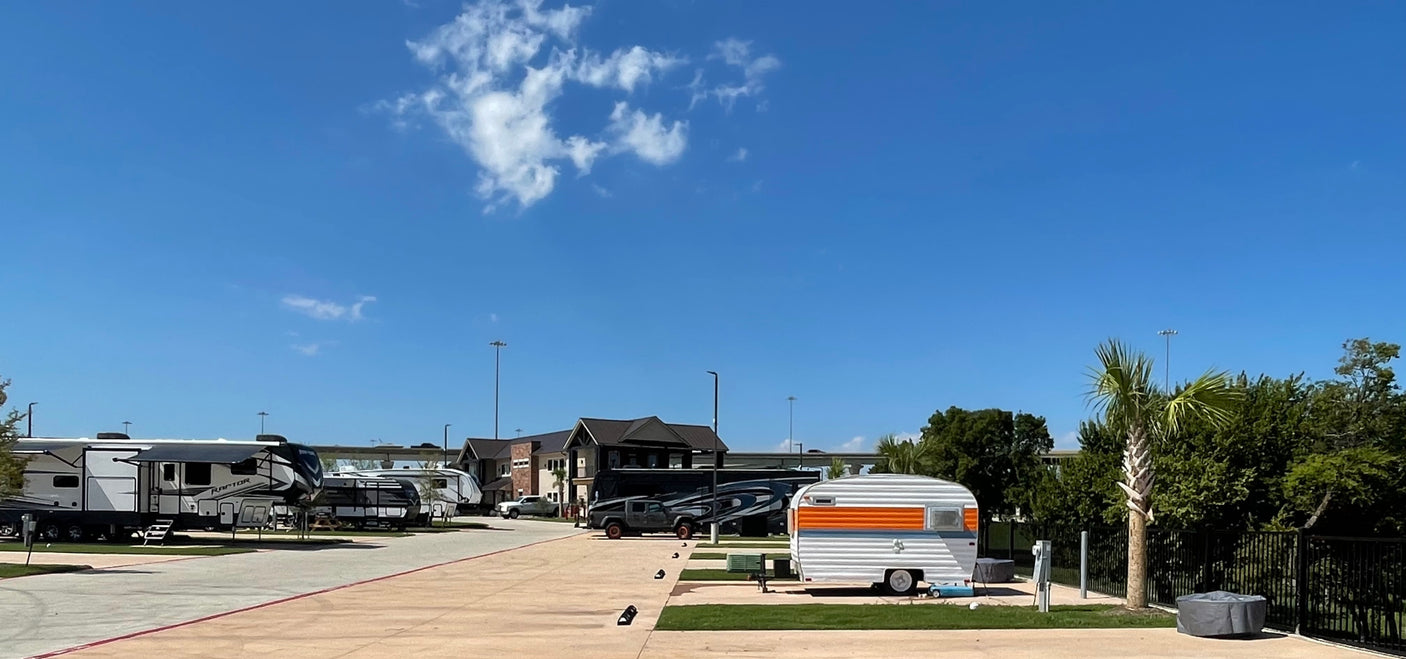 RV park with diverse campers, featuring a vintage travel trailer. Your next RV rental journey starts here!