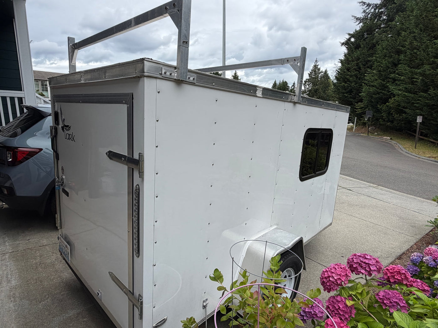 parked in a driveway. Perfect for an RV rental or small adventures.|A white cargo trailer — photo 4