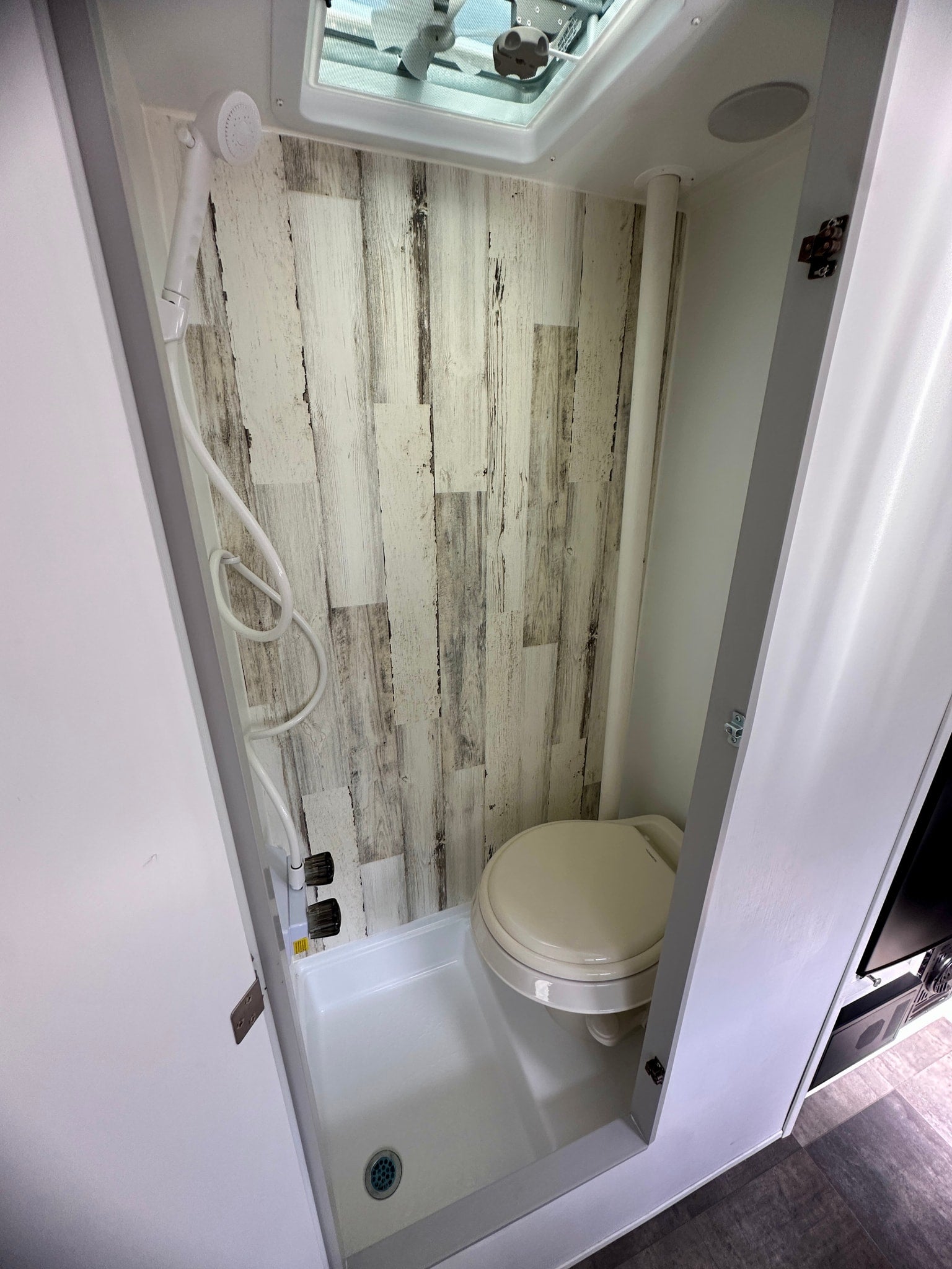 featuring mountain graphics. Ideal for camping and travel adventures.|RV rental compact wet bath featuring a toilet
