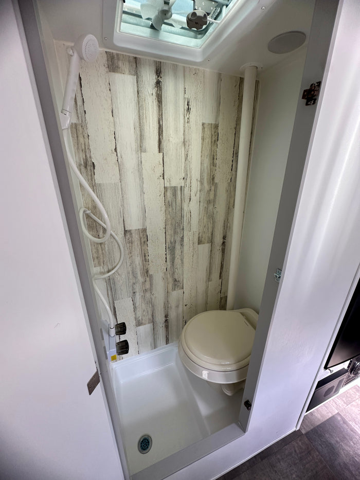 featuring mountain graphics. Ideal for camping and travel adventures.|RV rental compact wet bath featuring a toilet