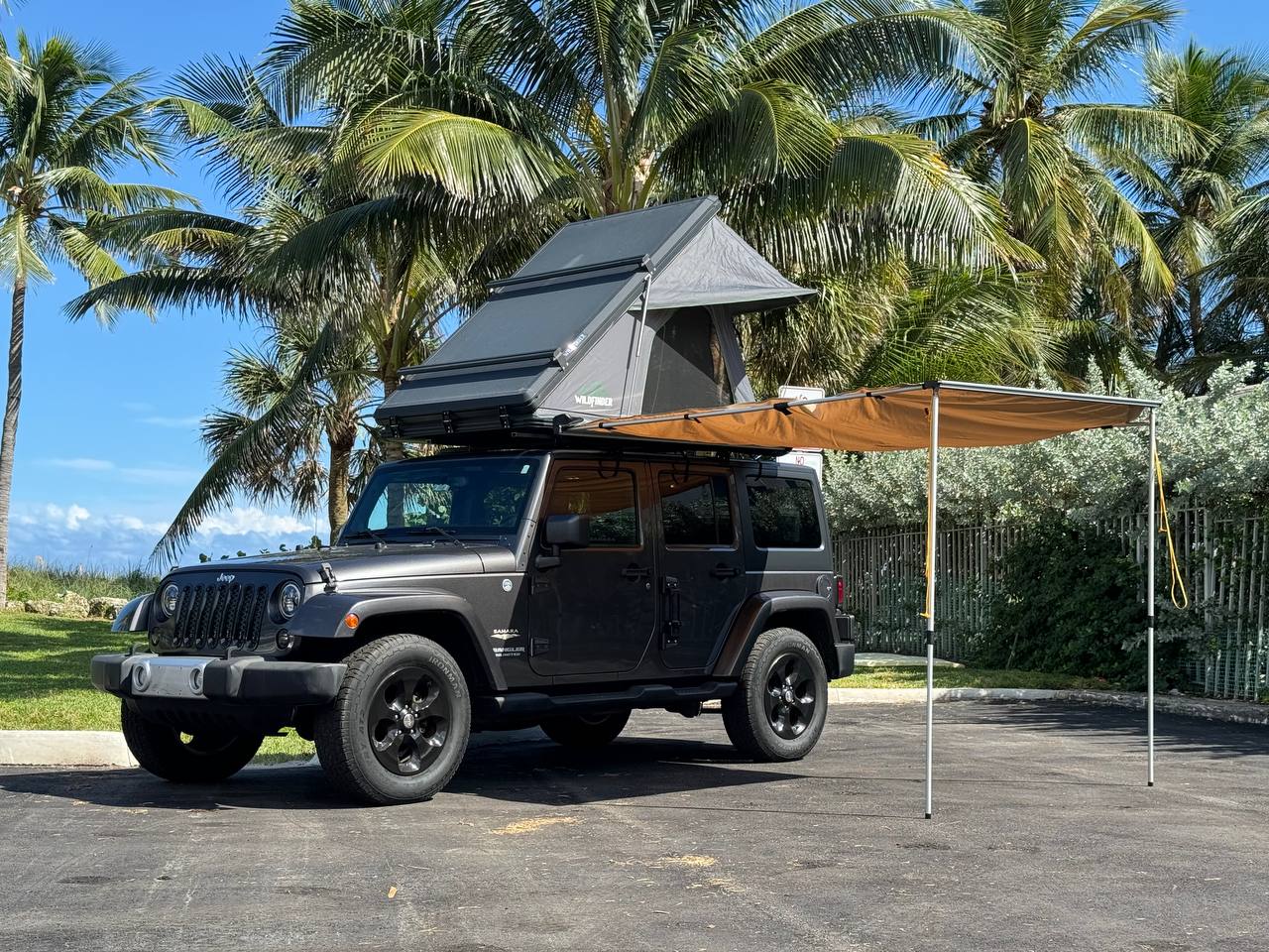 Adventure-ready Jeep Wrangler with rooftop tent and awning, ideal for RV rental exploration along the coast. — photo 13
