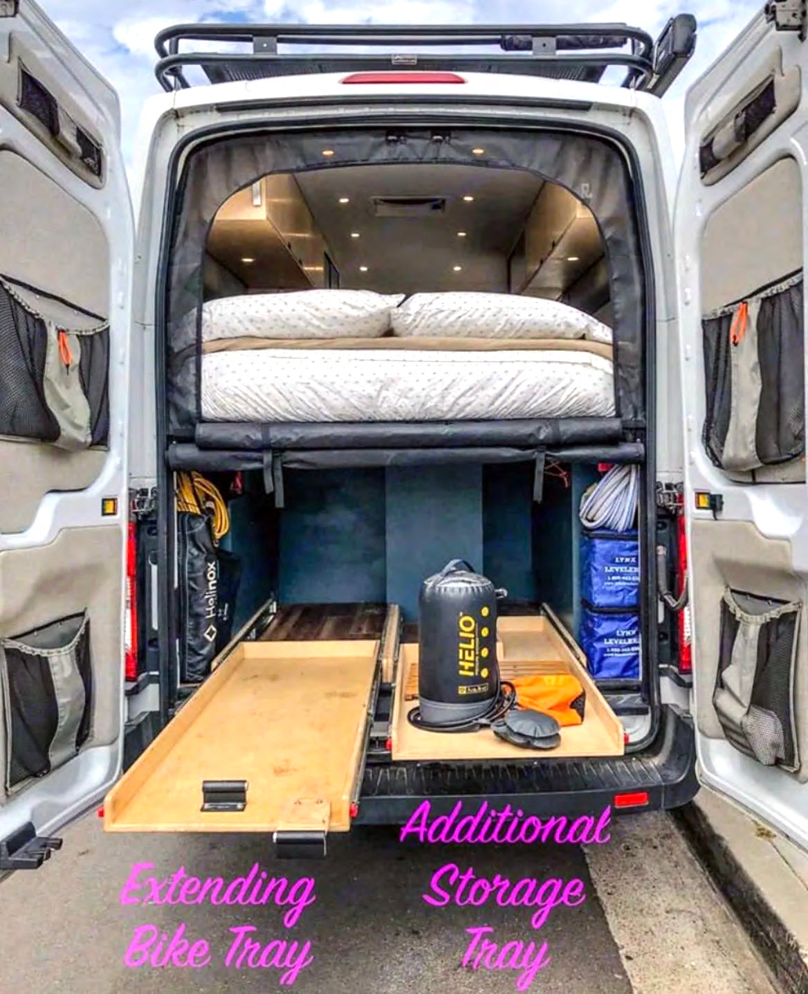 RV rental interior view: elevated bed, extending bike tray, & additional storage show a well-equipped camper van.