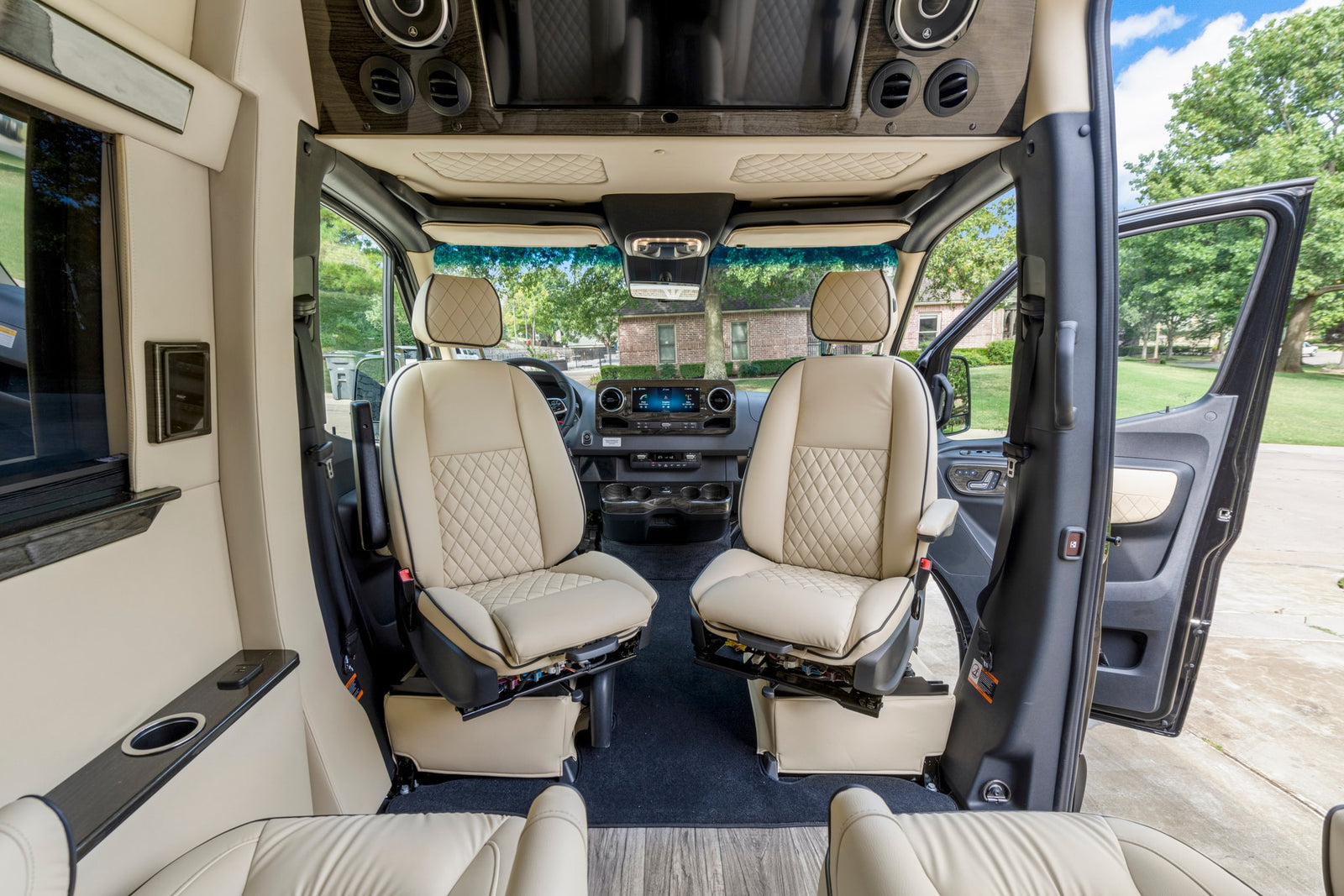Luxurious RV rental interior, showing swivel front seats & dashboard, offering comfort & style.