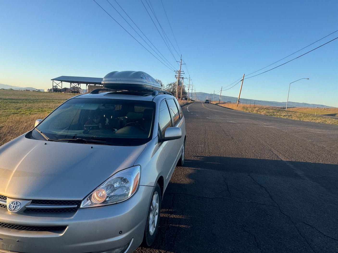 parked by a greenhouse. Perfect for an affordable RV rental alternative.|Minivan camper