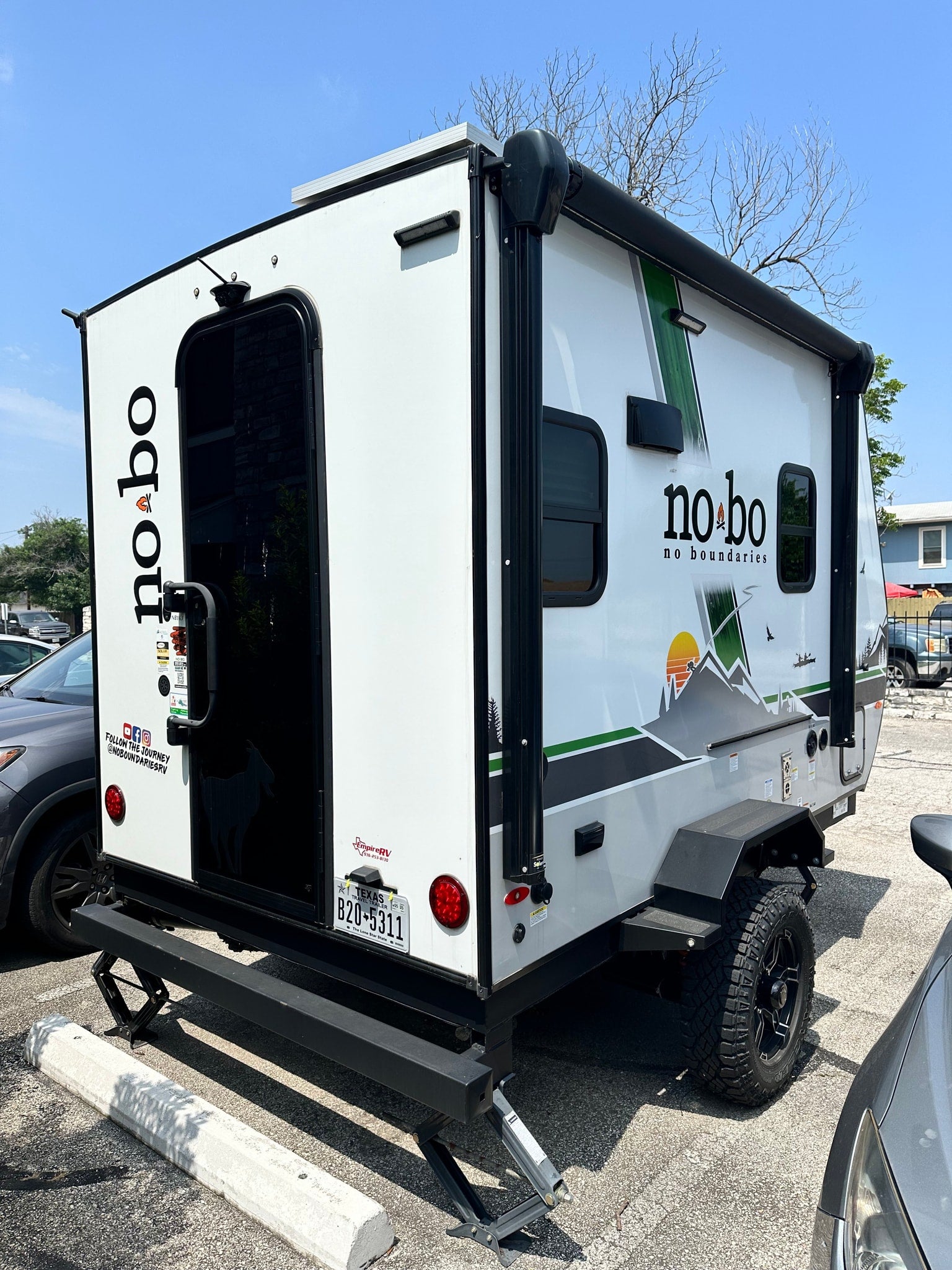 This "No Boundaries" off-road travel trailer RV rental, parked with stabilizers, awaits its next adventure.