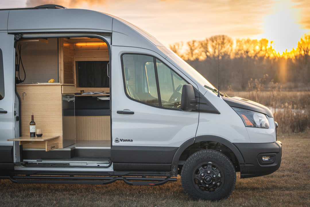 set within a cozy wooden camper van with custom cabinets and warm lighting.|RV rental utility drawer in a camper van. Organized storage for water hose